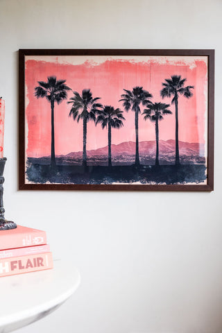 Lifestyle image of Pink Sunset A2 Art Print in a walnut frame on a light background.