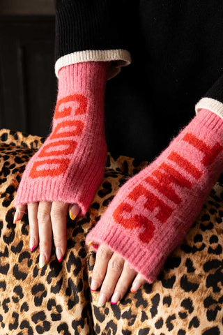 The Pink & Red Good Times Handwarmers being worn by a model resting their hands on a leopard print surface.