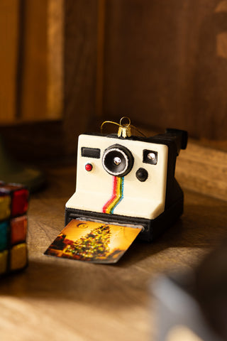 The Polaroid-Inspired Camera Christmas Tree Decoration displayed on a wooden surface.