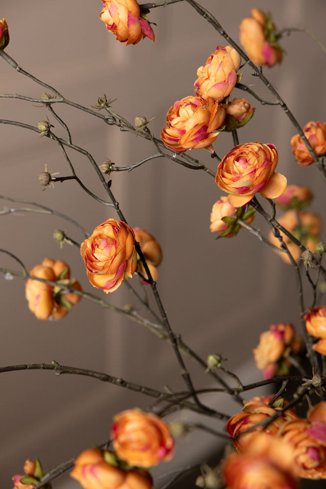 Lifestyle image of the Pretty Faux Ranunculous Stem in Blood Orange