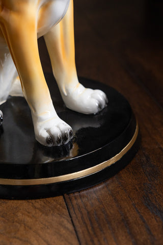 Close up of the Quirky Dog Side Table, showing the black and gold base as well as the dog's paws.