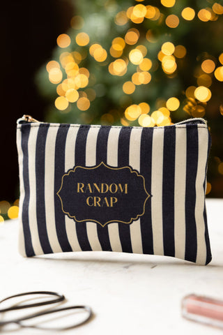 The Random Crap Striped Canvas Pouch shown on a marble surface. 