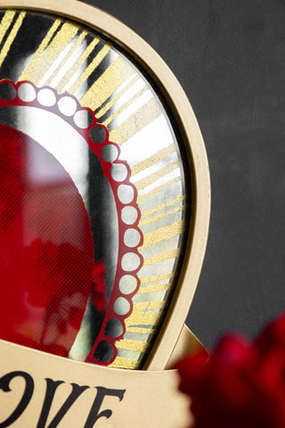 Close-up of the Rebel Of Love Heart-Shaped Wall Mirror in front of a dark wall.