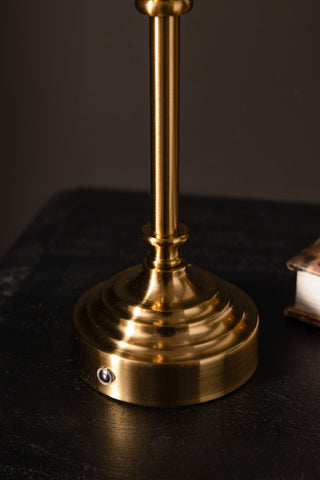 Brass lamp base on a dark surface