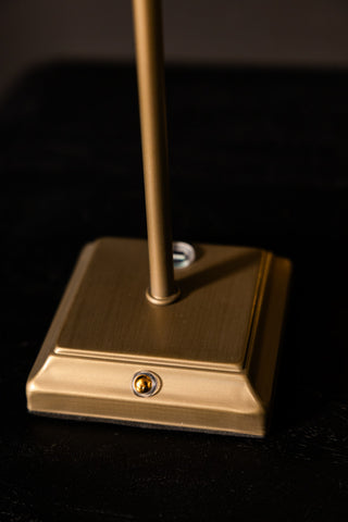 A table lamp base on a dark surface.