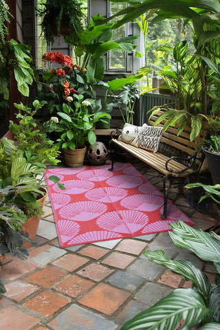 Lifestyle image of the Recycled Plastic Garden Rug In Pink & Red