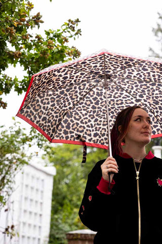 The inside of the Leopard Compact Umbrella shown in the rain. 
