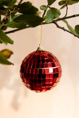 Close-up of the Red Disco Ball Christmas Tree Decoration hanging from a branch.