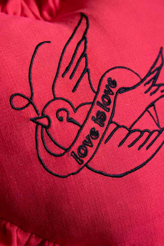 A detail image of the embroidery on the Red Love Heart Cushion With Ruffles.