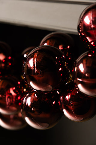 Close-up of the Red Antique-Effect Bauble Christmas Garland in front of a dark background.