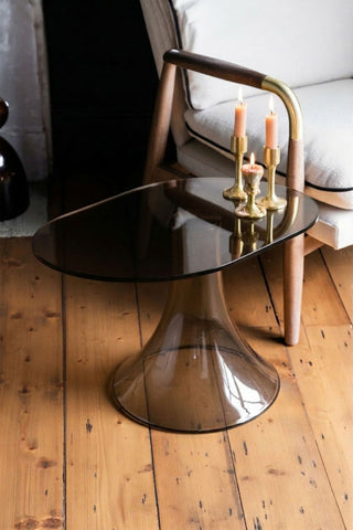 The Retro Asymmetric Side Table in Espresso styled with lit candles on, next to a chair.
