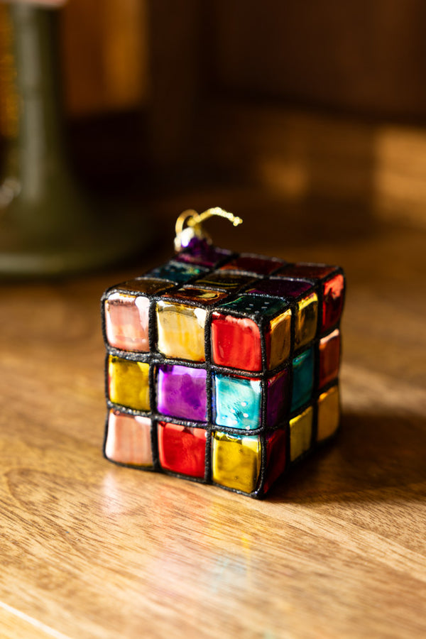 The Retro Colourful Cube Christmas Tree Decoration displayed on a wooden surface.