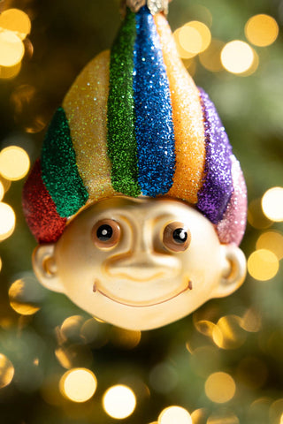 Close-up of the face of the Retro Troll-Inspired Christmas Tree Decoration with fairy lights in the background.