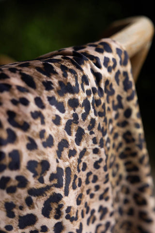 Detail of the Signature Leopard Print Velvet Throw with Tassels shown on a chair. 