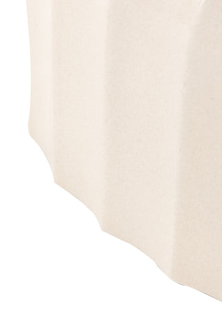 Close-up of the side of the Ribbed Edge Round Coffee Table In Ivory on a white background.