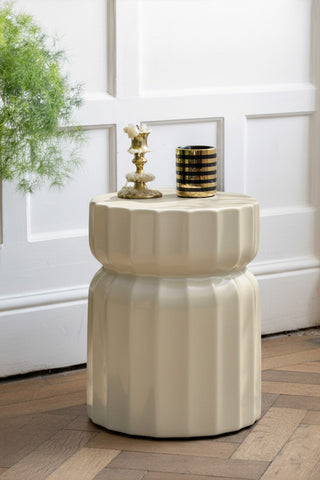 The Ribbed Edge Round Side Table in Ivory Glaze styled with some candles on.