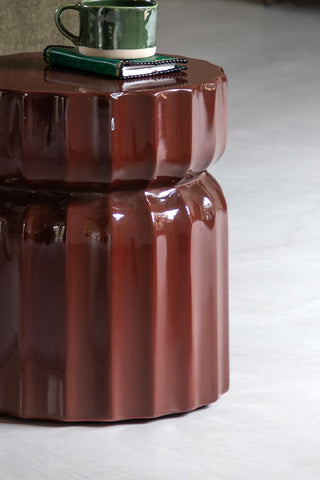 Close-up of the Ribbed Edge Round Side Table in Rust Glaze with a mug and book on top.