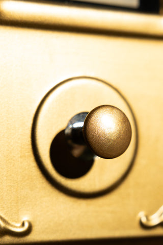 The button of the Ring For Refills Gold Wall Ornament. 