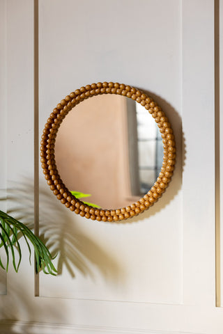 Round Bobbin Frame Mirror shown on a panelled wall. 