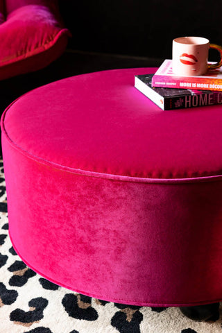 Close-up of the Round Footstool in Harry's Hot Pink Velvet with two books and a mug on.
