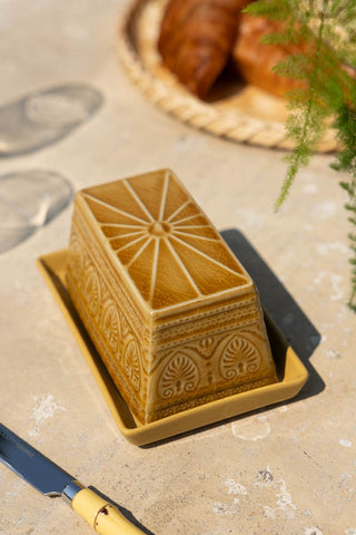 The Rustic Mustard Yellow Butter Dish styled on an outdoor table in the sun.