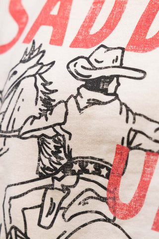 Close-up of the cowboy design on the Saddle Up Cowboy Sweatshirt in Oat.