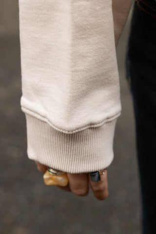 Close-up of the cuff of the Saddle Up Cowboy Sweatshirt in Oat.