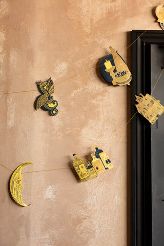 The Samhain Sewn Paper Halloween Garland shown hanging across a black doorframe. 