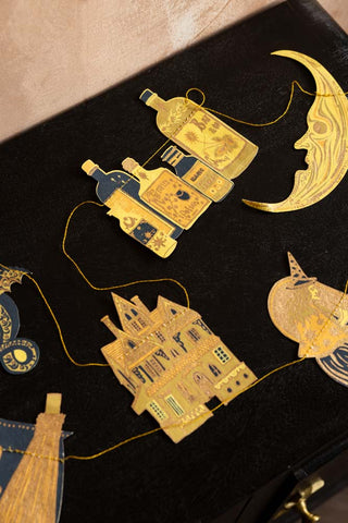 The house, moon, potion and witch of the Samhain Sewn Paper Halloween Garland. 