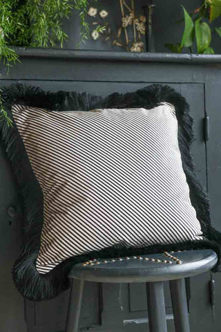 Lifestyle image of the Sand Stripe Velvet Fringe Feather Filled Cushion