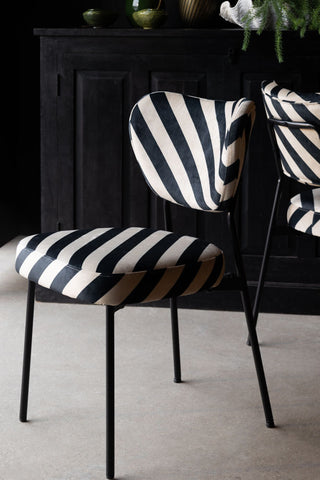 The Set of 2 Dining Chairs in Black & Sand Stripe with a black sideboard in the background with some accessories on.