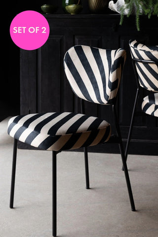 The Set of 2 Dining Chairs in Black & Sand Stripe in front of a black sideboard, with a pink circle with the words 'set of 2'. 