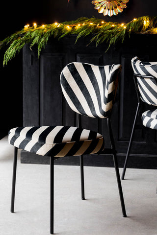 The Set of 2 Dining Chairs in Black & Sand Stripe styled in front of a black sideboard with fairy lights and greenery on.
