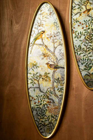 One of the Set of 2 Framed Oval Chinoiserie Wall Hangings shown on the wall, revealing the bird and tree print. 