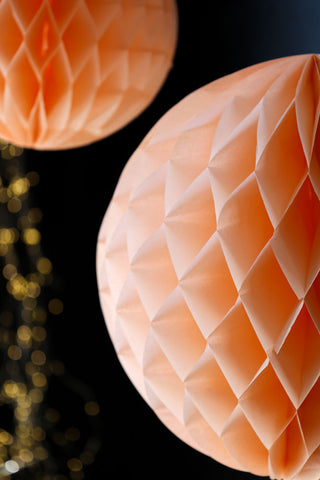 Close-up image of the Set Of 2 Peach Honeycomb Ball Decorations