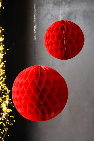 Lifestyle image of the Set Of 2 Red Honeycomb Ball Decorations