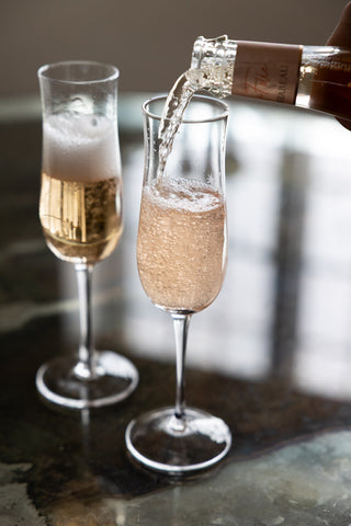 Image of the Set Of 2 Etched Star Champagne Flutes with champagne being poured