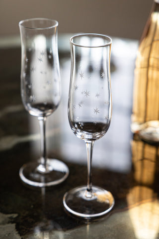 Image of the Set Of 2 Etched Star Champagne Flutes on a table