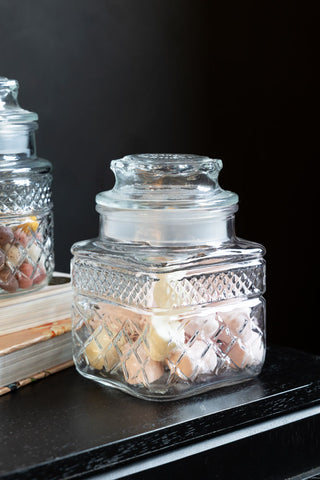 The set of two Set Of 2 Vintage-Style Glass Storage Jars styled on a sideboard with some books.