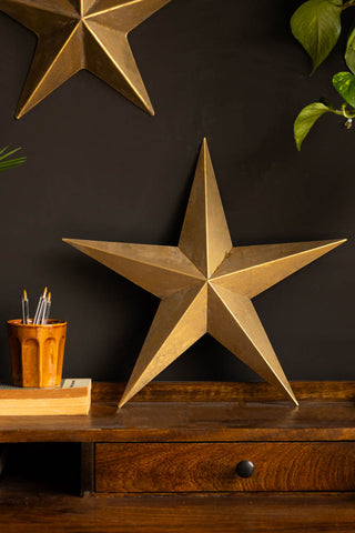 Lifestyle image of the Set Of 3 Antique Gold Metal Stars on desk closeup