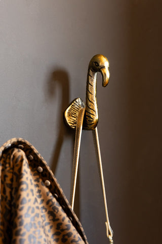 The Set of 2 Antique Gold Flamingo Head Coat Hooks shown holding a bag and jacket. 