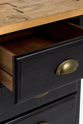 Close-up of the open drawer of a black wooden bedside table.
