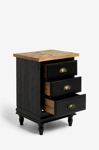 A black wooden bedside table with all three drawers open, in front of a white background.