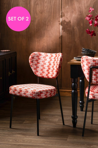 The Set of 2 Dining Chairs in Lips Print Velvet styled with a dining table, with a pink circle that says 'set of 2'. 