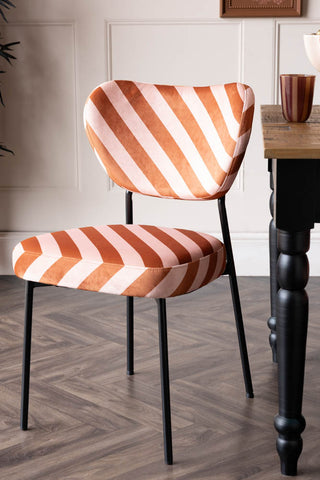 One of the Set of 2 Dining Chairs in Pink & Amber Stripe next to a dining table.