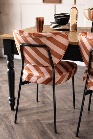 The Set of 2 Dining Chairs in Pink & Amber Stripe seen from behind at a dining table.