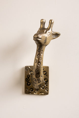 One of the Set of 2 Gold Giraffe Coat Hooks on a white wall.