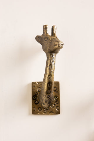 Close-up of one of the Set of 2 Gold Giraffe Coat Hooks on a white wall.