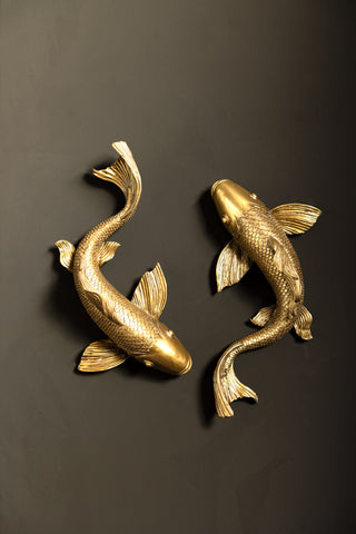 The Set of 2 Gold Koi Fish Wall Art styled on a black wall.