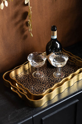 The Set of 2 Gold & Leopard Serving Trays styled with a bottle and two cocktail glasses.